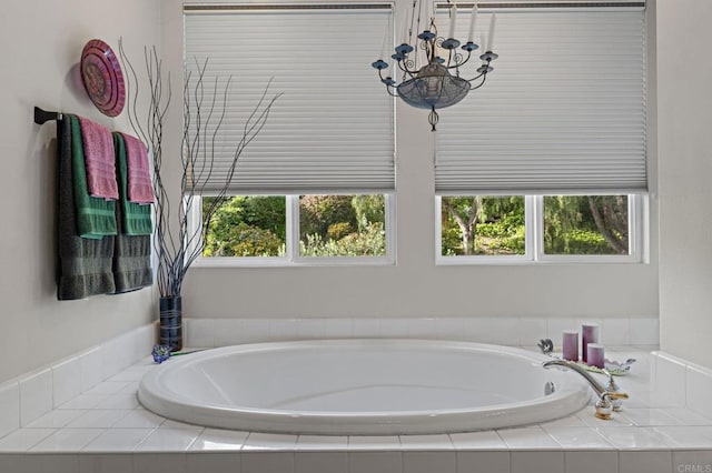 full bath featuring a notable chandelier and a garden tub