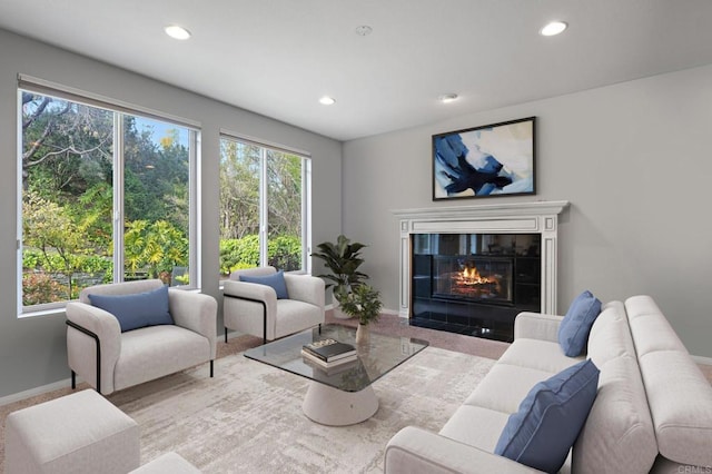 living area featuring baseboards, a tiled fireplace, and recessed lighting