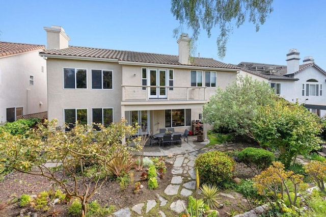 5054 Seachase Way, San Diego, CA 92130 - back of house with a balcony, a chimney, a patio area, stucco siding, and a tiled roof