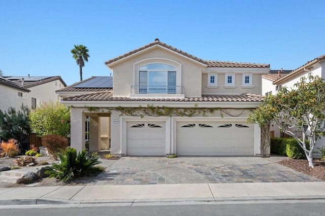 5054 Seachase Way, San Diego, CA 92130 - mediterranean / spanish-style home featuring a tile roof, an attached garage, stucco siding, solar panels, and decorative driveway