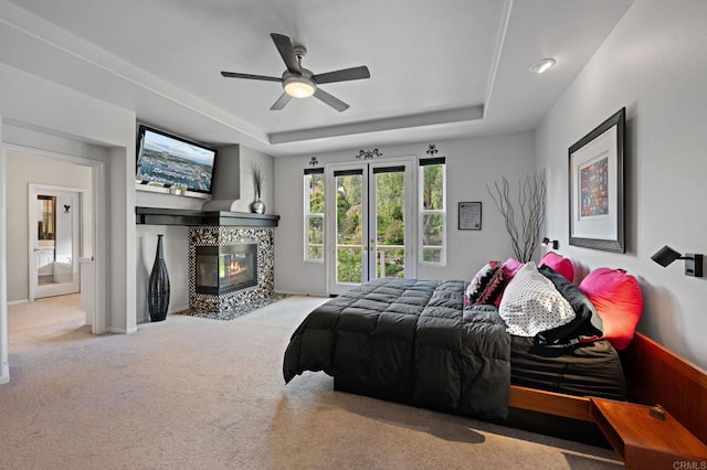 5054 Seachase Way, San Diego, CA 92130 - bedroom featuring a raised ceiling, carpet flooring, a tile fireplace, and a ceiling fan
