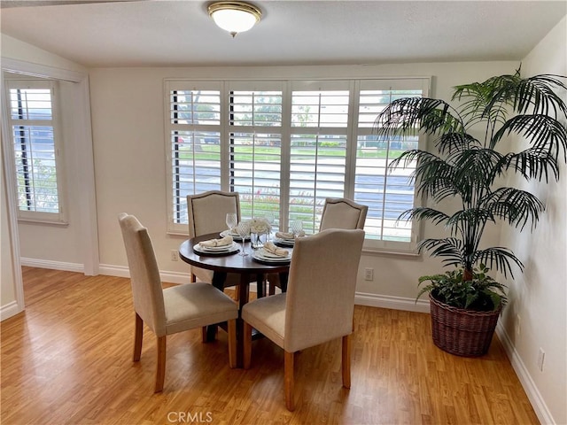 dining space featuring light wood finished floors and baseboards