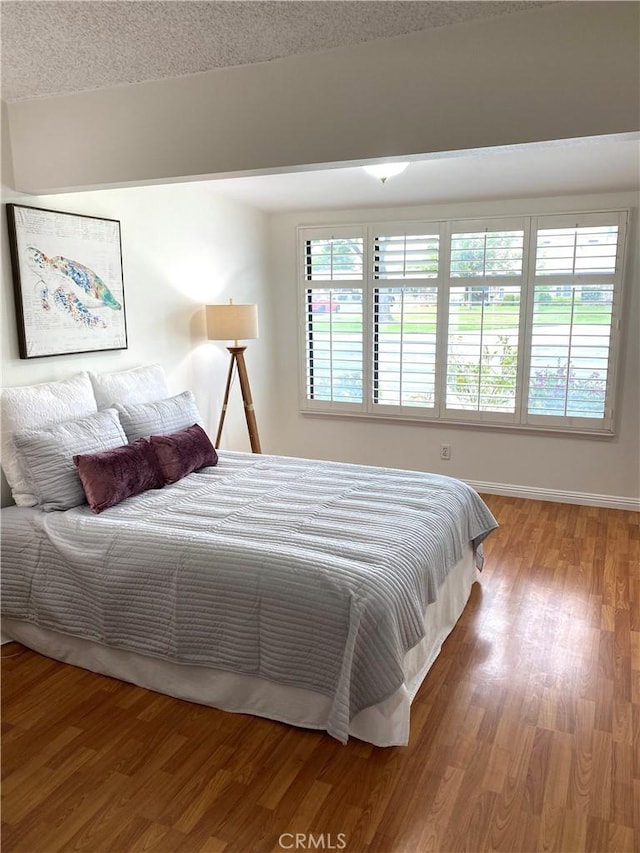 bedroom featuring wood finished floors and baseboards