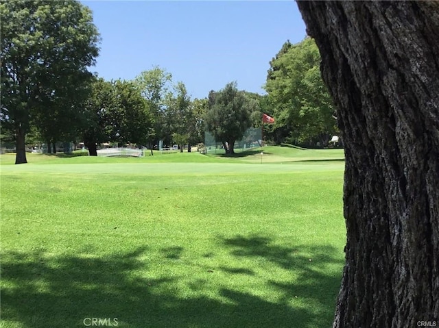 surrounding community with a yard and golf course view