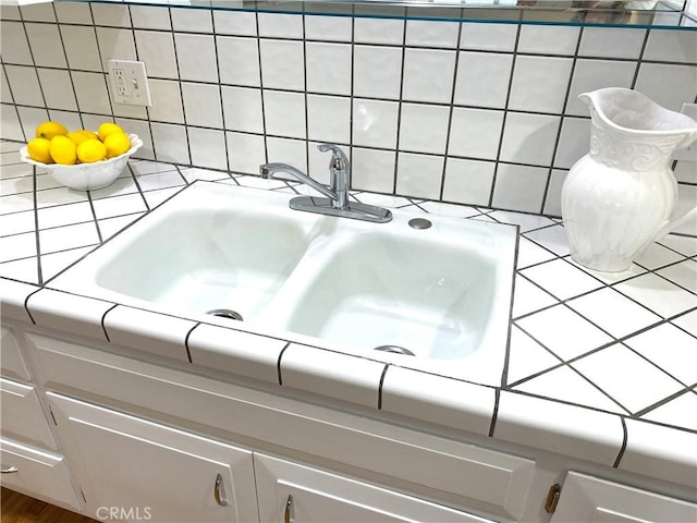 bathroom with decorative backsplash and a sink