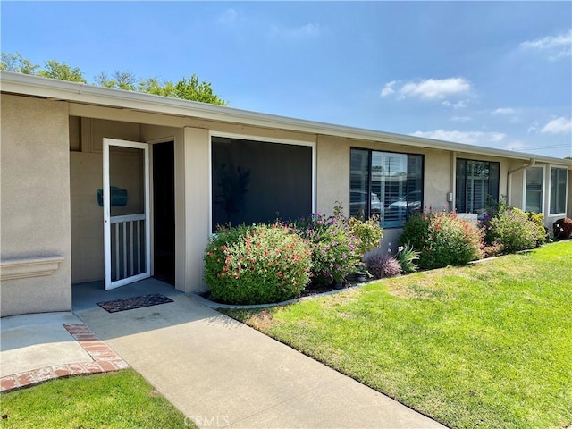 13310 Fairfield Ln Unit M7-176B, Seal Beach, CA 90740 - doorway to property with stucco siding and a yard