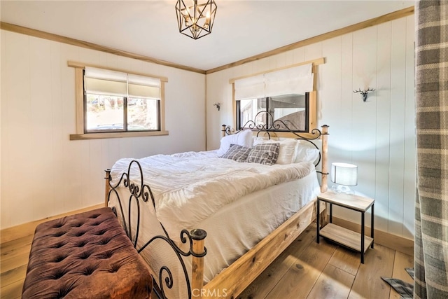 bedroom with crown molding, wood-type flooring, and baseboards