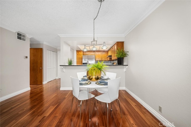 dining area featuring a textured ceiling, dark wood-style flooring, baseboards, and crown molding