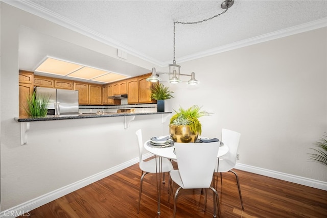 dining room featuring ornamental molding, dark wood-type flooring, baseboards, and a textured ceiling