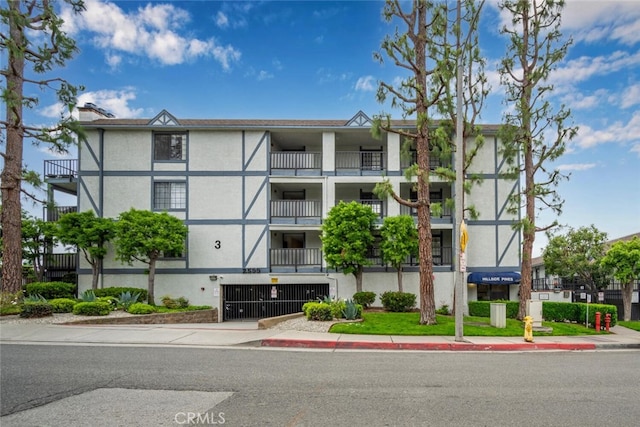 view of apartment building / complex featuring an attached garage, concrete driveway, and central AC unit