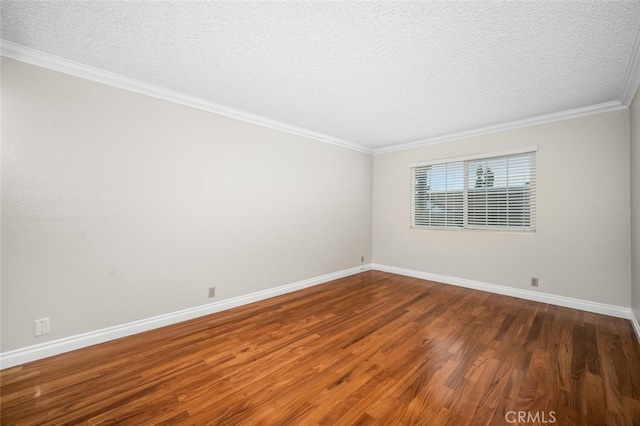 unfurnished room with wood finished floors, a textured ceiling, baseboards, and crown molding