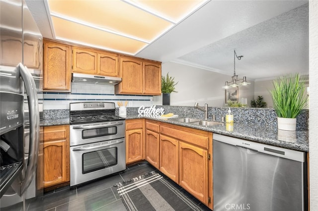 kitchen featuring appliances with stainless steel finishes, a sink, under cabinet range hood, crown molding, and brown cabinetry