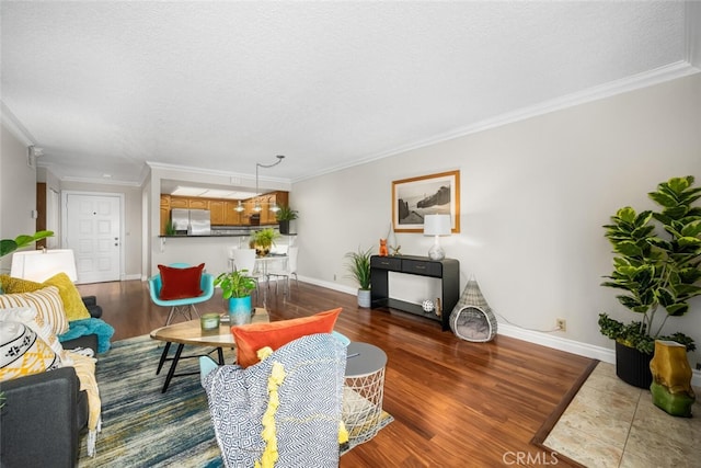 living area featuring wood finished floors, crown molding, a textured ceiling, and baseboards