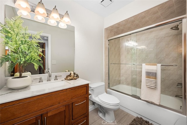 full bathroom featuring shower / bath combination with glass door, vanity, and toilet