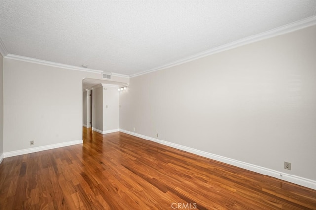 spare room featuring baseboards, wood finished floors, and ornamental molding