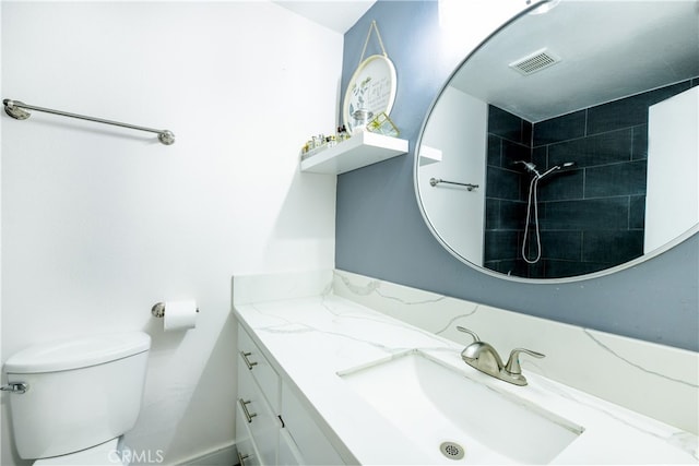 full bathroom with vanity, toilet, visible vents, and a tile shower