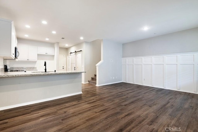 2785 Berry Loop Privado Unit 12, Ontario, CA 91761 - kitchen with a barn door, a sink, dark wood finished floors, white cabinetry, and recessed lighting