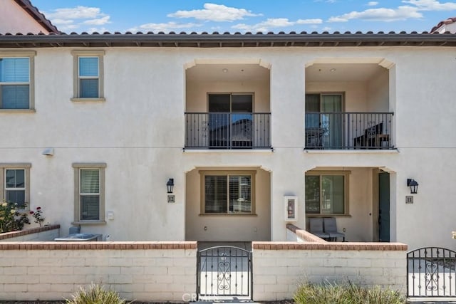 2785 Berry Loop Privado Unit 12, Ontario, CA 91761 - view of front facade featuring a gate, a fenced front yard, and stucco siding