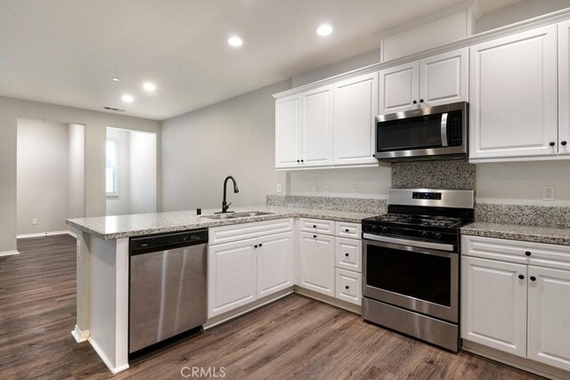 2785 Berry Loop Privado Unit 12, Ontario, CA 91761 - kitchen with stainless steel appliances, a sink, a peninsula, dark wood finished floors, and recessed lighting