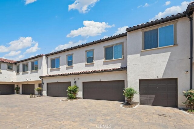 2785 Berry Loop Privado Unit 12, Ontario, CA 91761 - view of front facade with an attached garage, stucco siding, and driveway