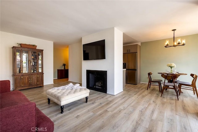 5875 Doverwood Dr Unit 309, Culver City, CA 90230 - living room featuring a chandelier, light wood-style flooring, and a fireplace