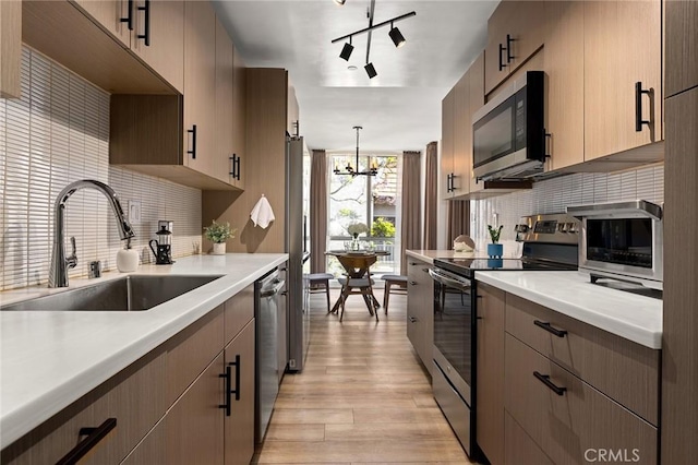 5875 Doverwood Dr Unit 309, Culver City, CA 90230 - kitchen with appliances with stainless steel finishes, a sink, a chandelier, and tasteful backsplash