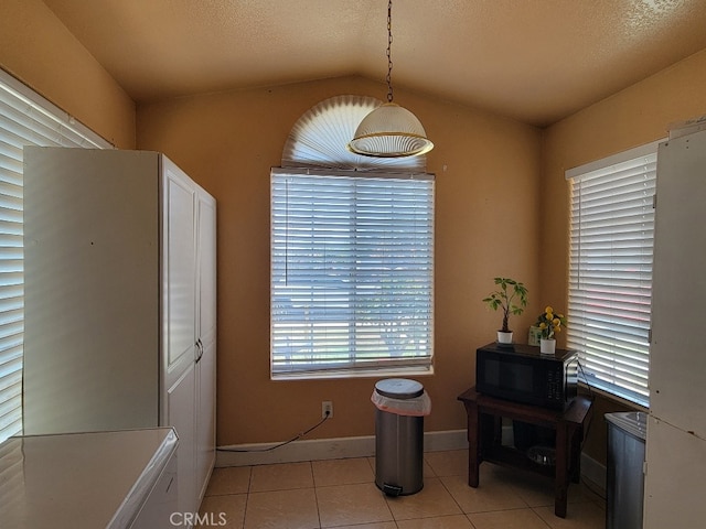 628 Vintner St, Los Banos, CA 93635 - dining space with light tile patterned floors, baseboards, and vaulted ceiling