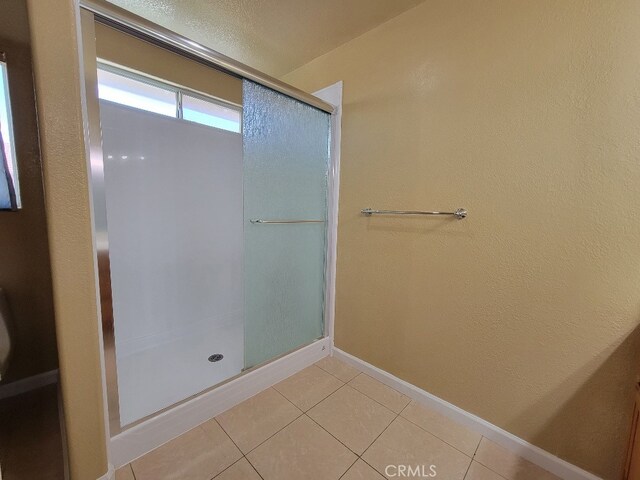628 Vintner St, Los Banos, CA 93635 - full bathroom with a shower with shower door, baseboards, and tile patterned floors