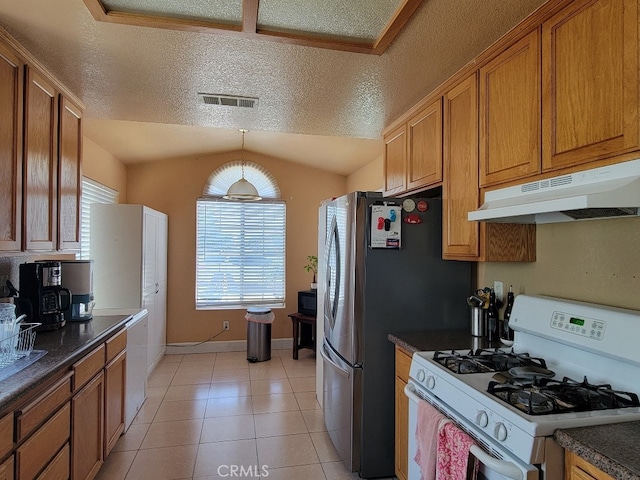 628 Vintner St, Los Banos, CA 93635 - kitchen featuring a textured ceiling, visible vents, white gas range oven, under cabinet range hood, and dark countertops