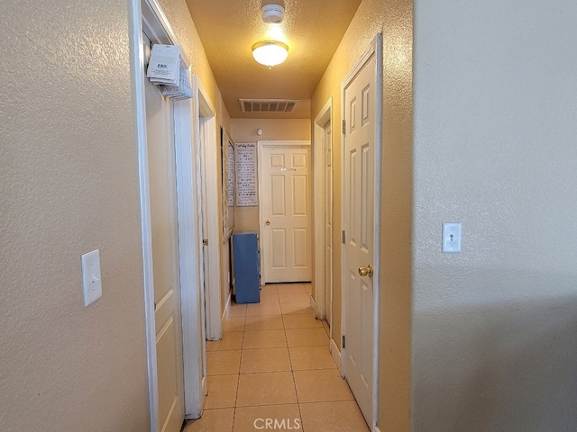 628 Vintner St, Los Banos, CA 93635 - hallway with light tile patterned flooring, a textured wall, baseboards, and visible vents