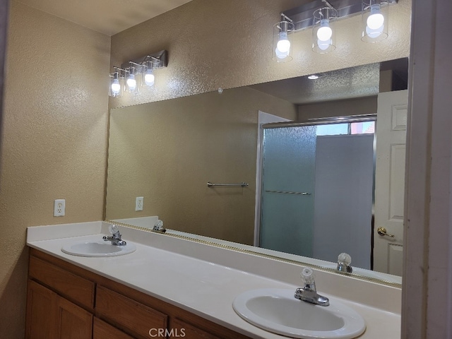 628 Vintner St, Los Banos, CA 93635 - full bath featuring double vanity, a stall shower, a sink, and a textured wall