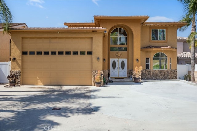 22255 Village Way Dr, Canyon Lake, CA 92587 - mediterranean / spanish-style home with stucco siding, an attached garage, driveway, and stone siding