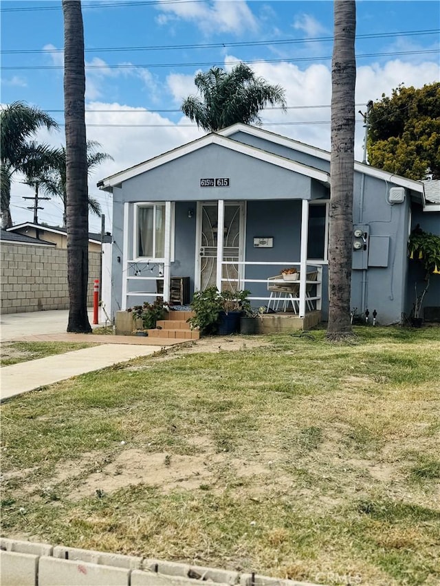 615 Emmett St, Santa Ana, CA 92707 - view of front facade with a front yard, stucco siding, a porch, and central air condition unit