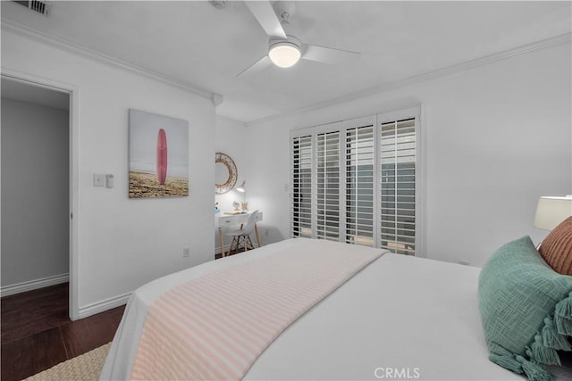 bedroom featuring crown molding, baseboards, ceiling fan, and wood finished floors