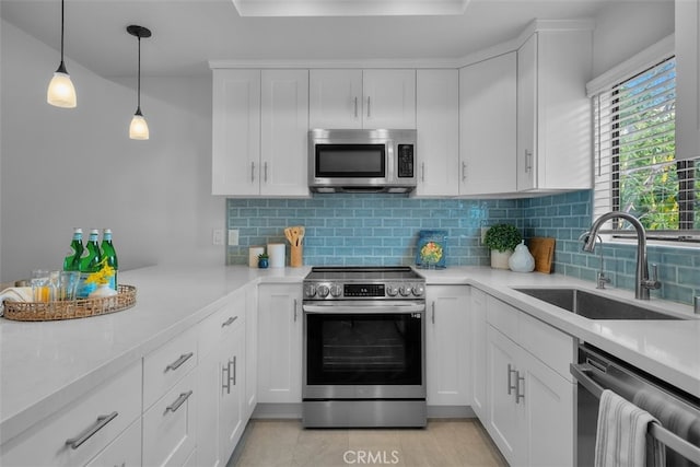 kitchen featuring a sink, white cabinets, backsplash, light countertops, and appliances with stainless steel finishes