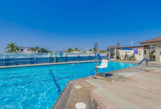 pool featuring fence and a patio area