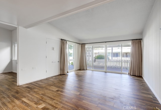 spare room with lofted ceiling, baseboards, and wood finished floors