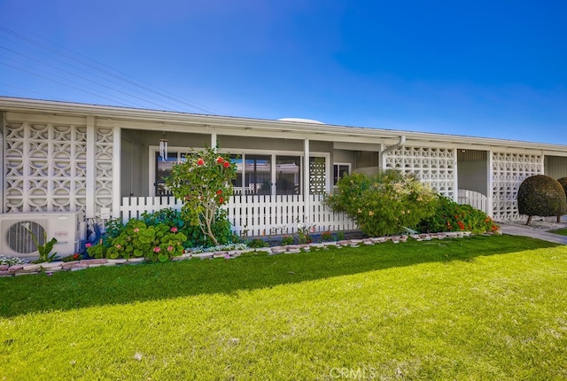 ranch-style house with ac unit and a front yard