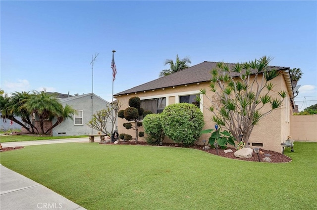 view of front of house with a front yard and stucco siding