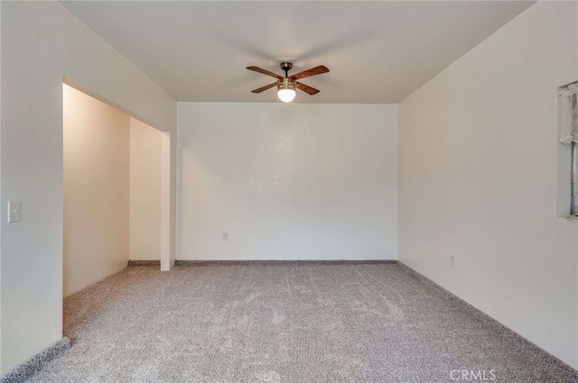 spare room with a ceiling fan and carpet floors