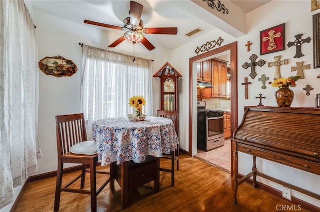 dining area with a ceiling fan, light wood-style flooring, and visible vents