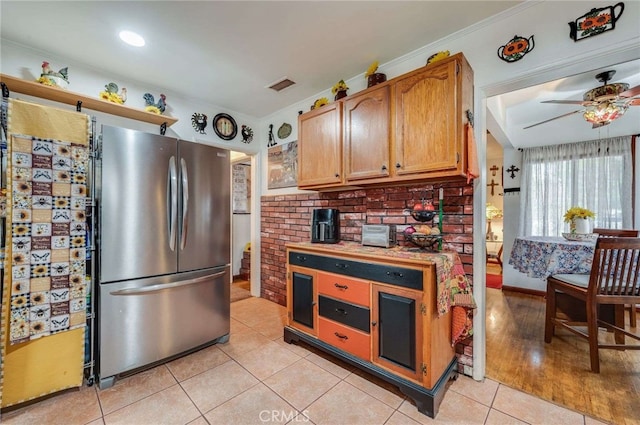 kitchen featuring freestanding refrigerator, light tile patterned flooring, visible vents, light countertops, and a ceiling fan