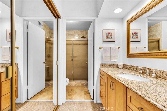 bathroom featuring vanity, a stall shower, and toilet