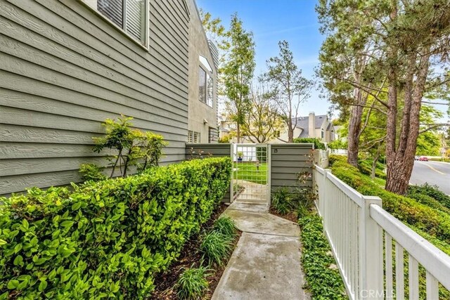 view of home's exterior with fence and a gate