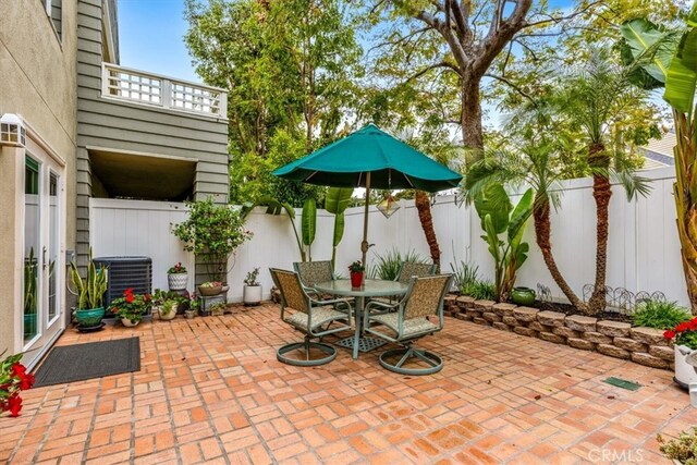 view of patio / terrace featuring central AC unit, a fenced backyard, and outdoor dining area