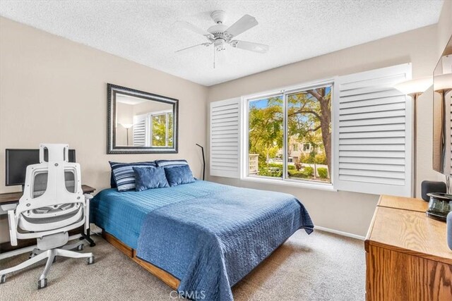 bedroom featuring carpet floors, a textured ceiling, baseboards, and ceiling fan