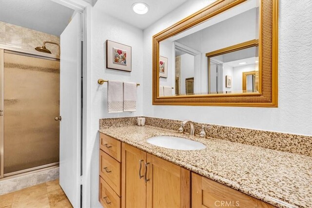 bathroom with a stall shower and vanity