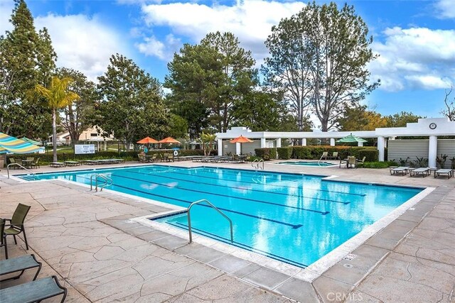 community pool with a patio and fence