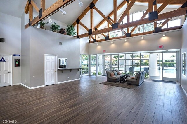 community lobby featuring high vaulted ceiling and beamed ceiling