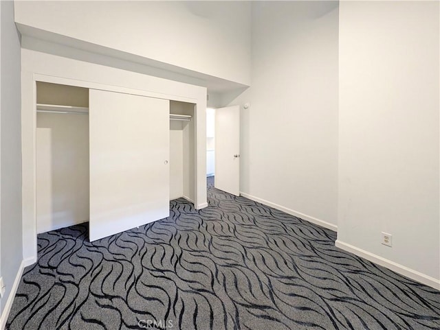 26770 Claudette St Unit 408, Canyon Country, CA 91351 - unfurnished bedroom with baseboards, dark carpet, and a closet